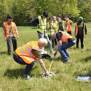 Judges measure the distance from the target to the rover-delivered first aid kit.